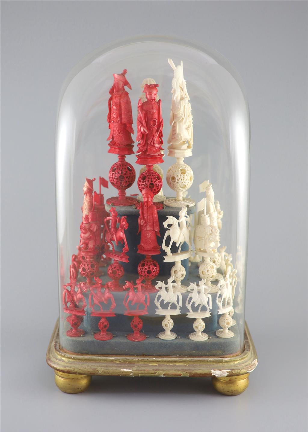 A set of 19th century Cantonese carved and red stained ivory chess pieces under dome, white king 20cm high